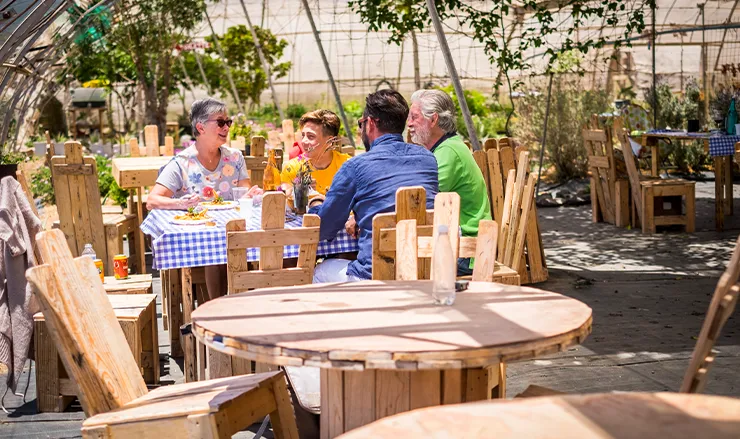 Goście restauracji jedzący posiłek na świeżym powietrzu w ogrodzie